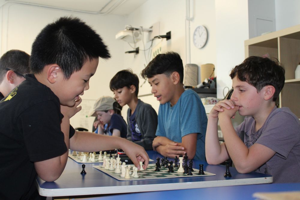 Kids playing chess at a CIC camp.